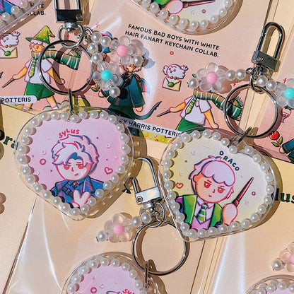 Keychains with cartoon character designs on a pink background
